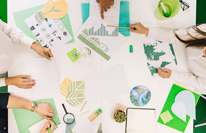 Team di professionisti che analizza grafici, dati ambientali e indicatori di sostenibilità su un tavolo di lavoro, immagine simbolo dell’articolo dedicato alla Carbon Neutrality, ai Science Based Target e alla transizione climatica delle imprese per la business unit EHS di Lifeanalytics