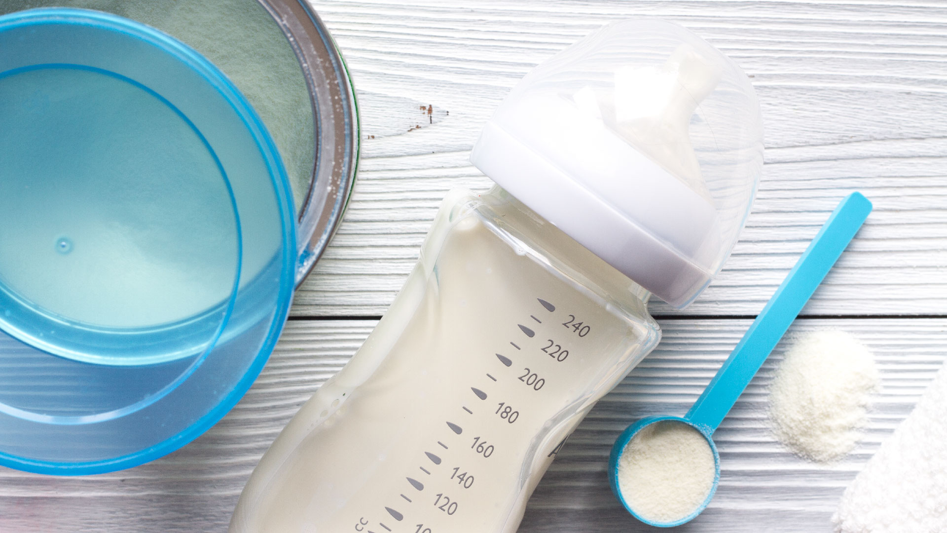Latte in polvere in contenitore di latta, misurino e all’interno di un biberon pronto per raccogliere il campionamento per le analisi di laboratorio, simbolo del servizio food baby food, novel food e integratori alimenti di Lifeanalytics