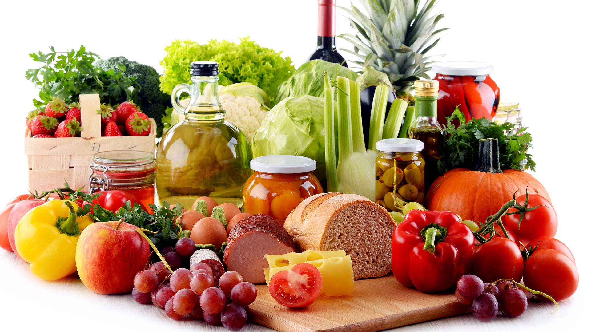 Immagine di una composizione di alimenti freschi e conservati come frutta, verdura, pane, formaggi, vino e conserve su piano da lavoro, simbolo di qualità e sicurezza alimentare, simbolo del corso dedicato alle Le certificazioni volontarie del settore alimentare