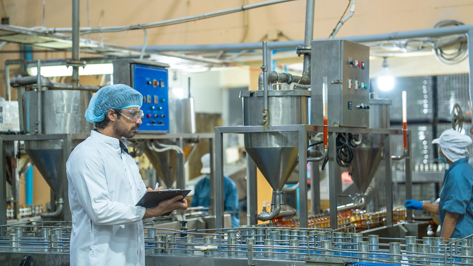 Immagine di tecnico alimentare con camice e cuffia che ispeziona il processo produttivo alimentare, simbolo del servizio dedicato alla gestione delle non conformità