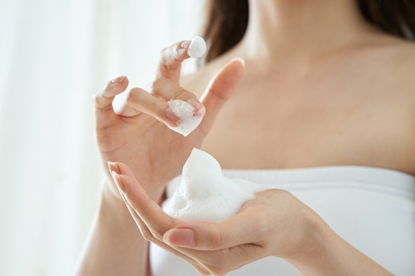 Donna applica mousse detergente viso skincare pulizia delicata schiuma cosmetica routine bellezza quotidiana, simbolo dell’articolo del blog dedicato alla neurocosmesi, quando la cosmetica e la neuroscienza iniziano a parlare la stessa lingua nell’ambito della business unit cosmetic & medical device di Lifeanalytics 