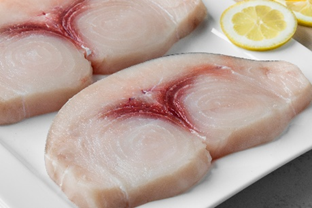 Trancio di pesce spada su un piatto con una fetta di limone, immagine simbolo di prodotti con presenza di mercurio oltre i limiti di legge