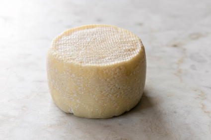 Immagine di formaggio fresco su un piano in marmo, simbolo di richiamo per rischio di contaminazione da Listeria monocytogenes.