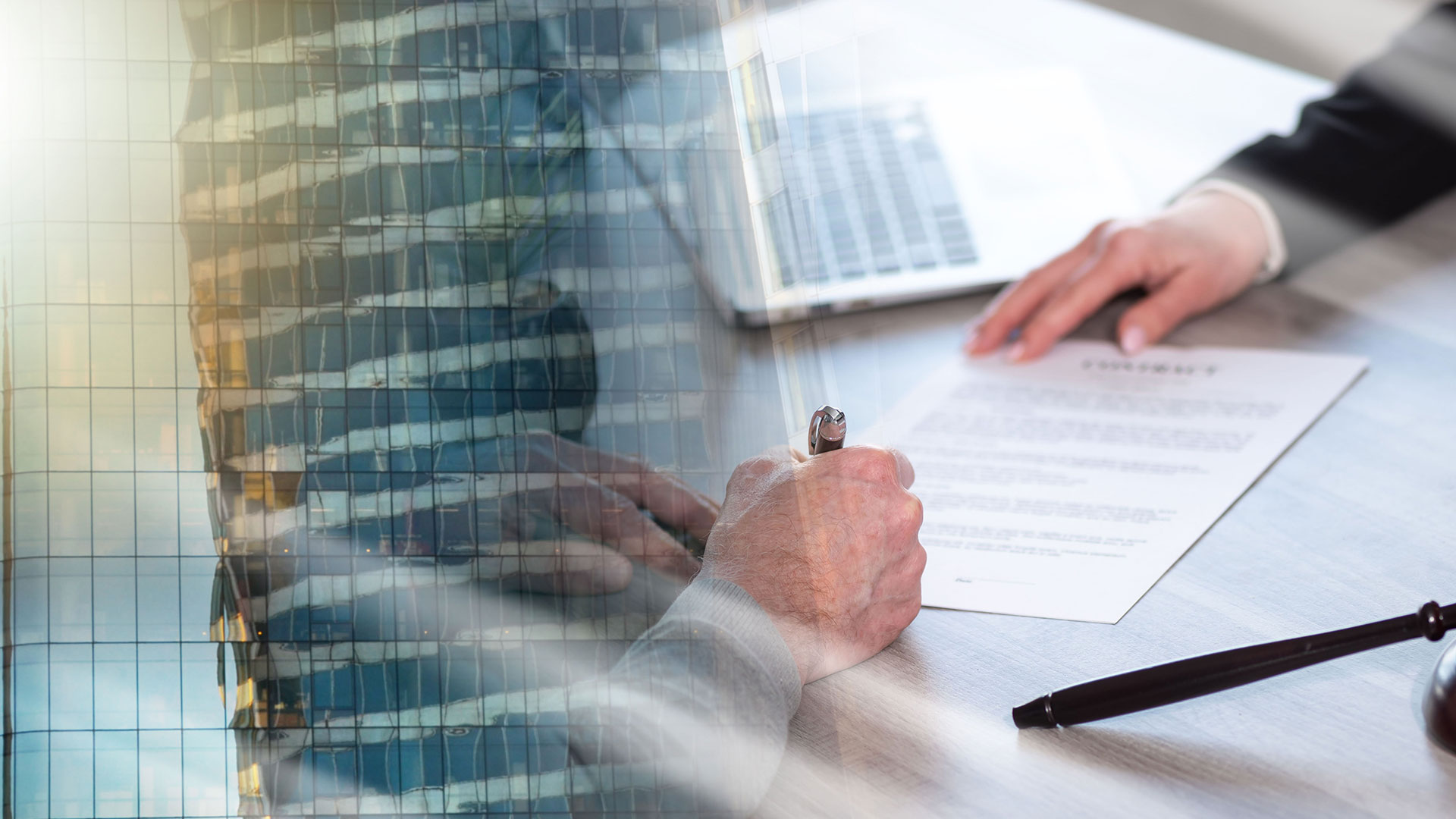 Immagine di una scrivania con oggetti legati alla legge come martelletto e plichi con sfondo di un edificio a vetri, simbolo del servizio dedicato all'implementazione sistemi normativa volontaria (IFS, BRC,  FSSC22000….)