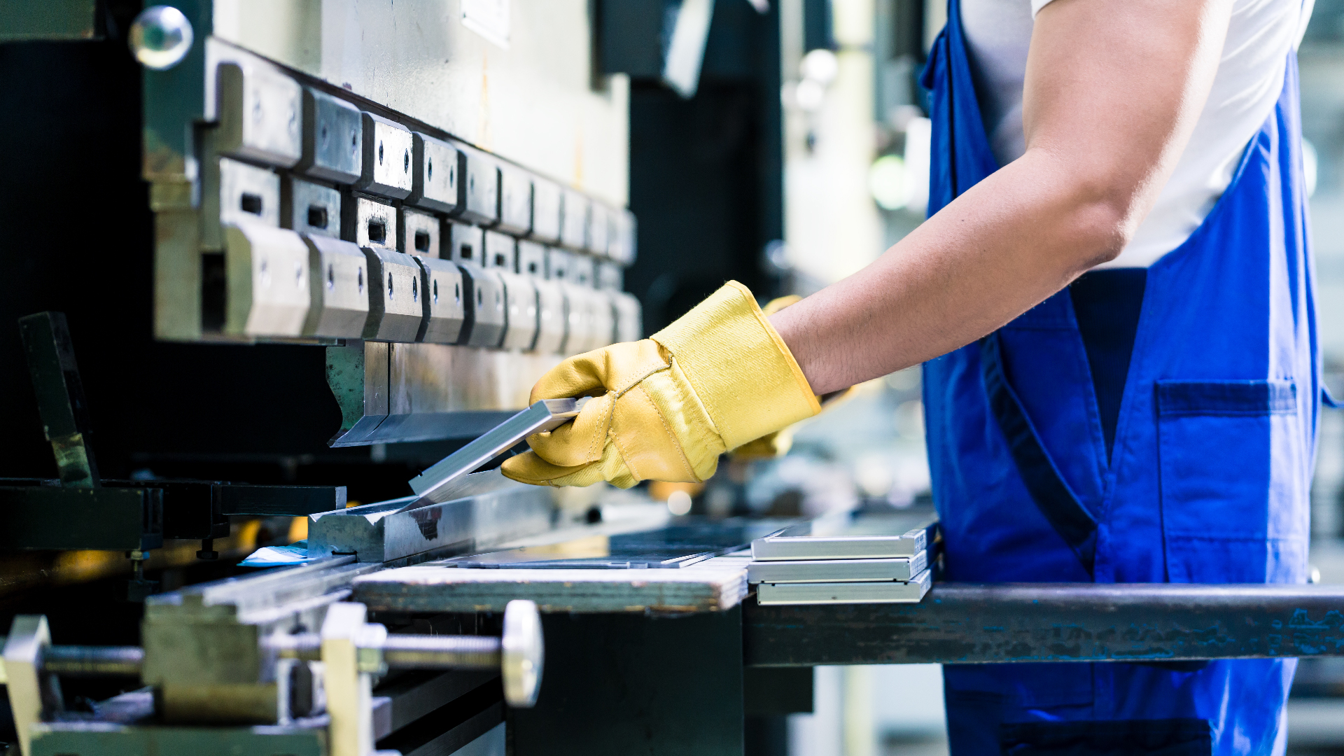 Lavoratore intento a effettuare un lavoro con un macchinario che rispetta le normative in merito alla sicurezza delle macchine